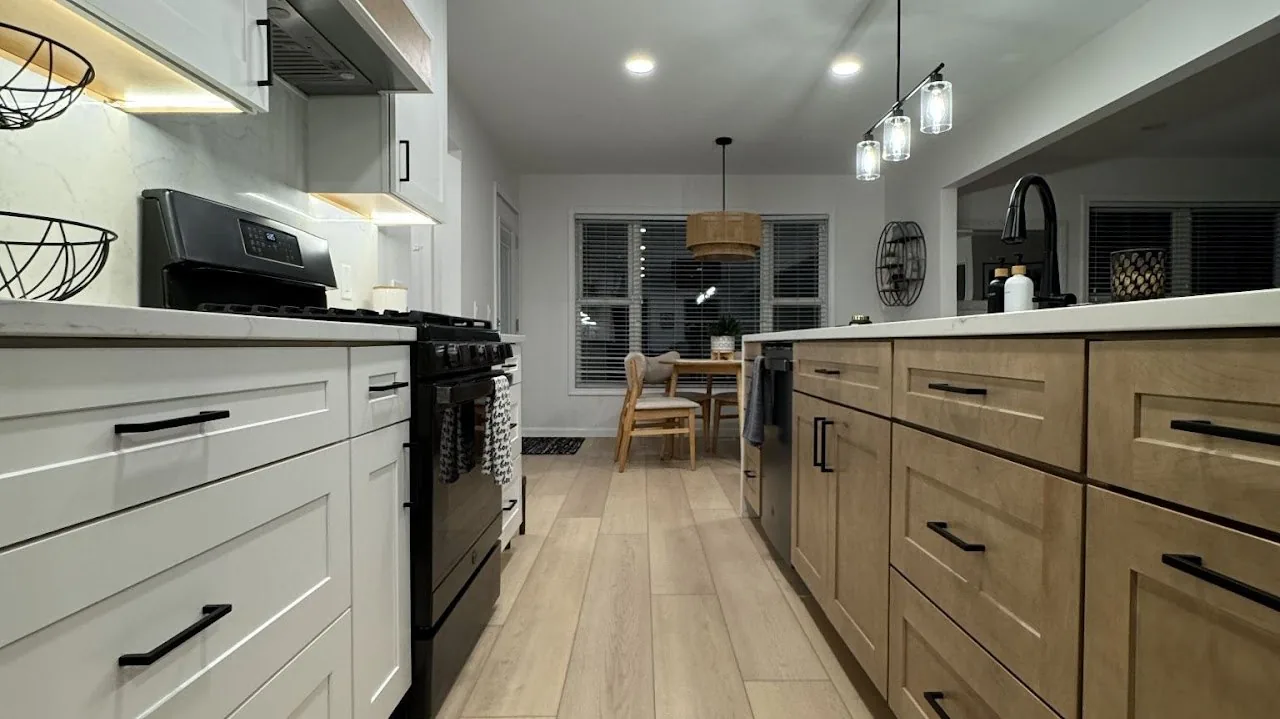 Two tone kitchen cabinetry with white uppers, natural wood lowers and matte black hardware