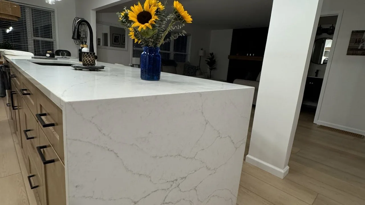 Quartz island with a waterfall edge and a matte black faucet