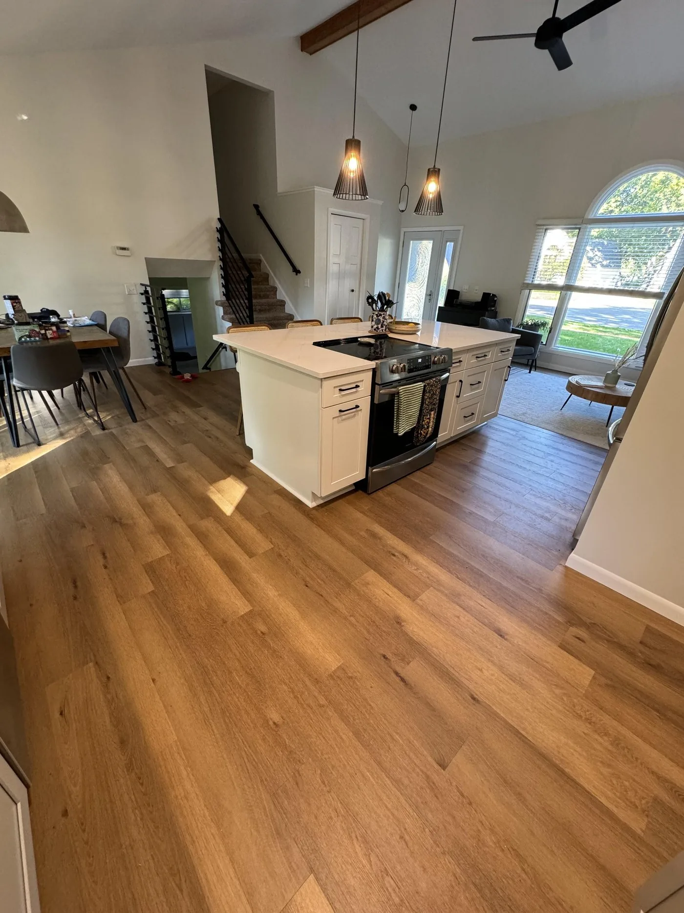 Wide plank luxury vinyl flooring running through an open kitchen and living room