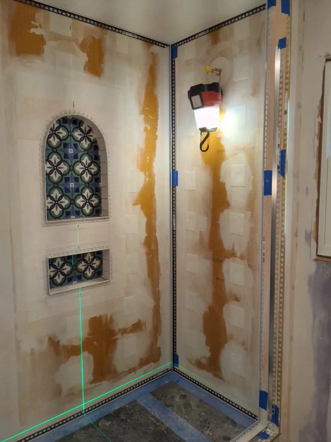 Shower walls sealed with orange waterproofing membrane before tile is set